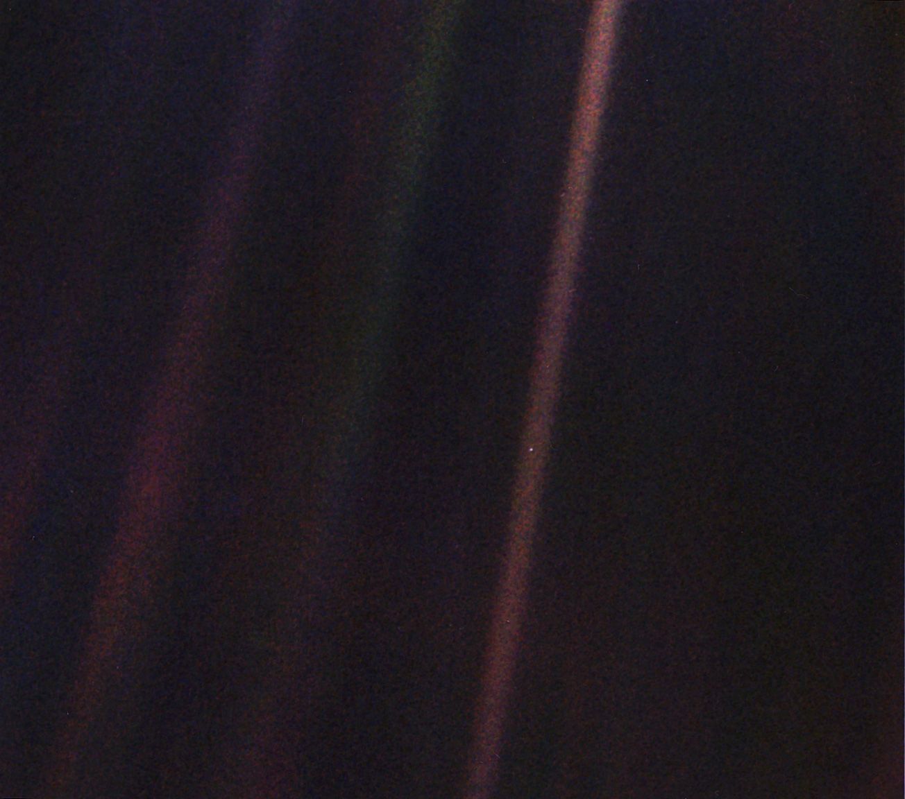 Earth as a small blue dot in a fuzzy beam of light.