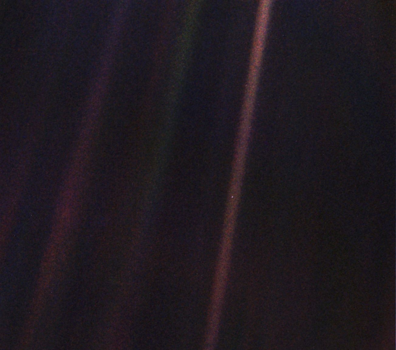Earth as a small blue dot in a fuzzy beam of light. Earth as a small blue dot in a fuzzy beam of light.